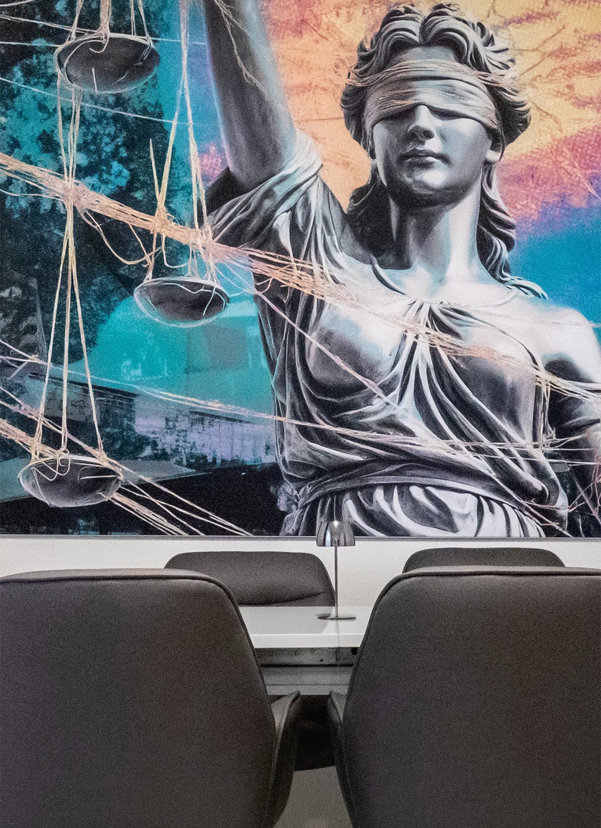Besprechungsraum Mit Justizia Bild und Besprechunsgtisch und Stühlen im Vordergrund Ausschnitt.